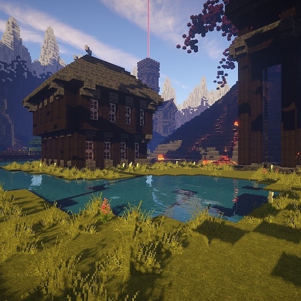 Digital landscape from a video game, featuring a medieval-style wooden house near a pond, surrounded by mountainous terrain and structures, with a bright beacon in the background under a clear sky.